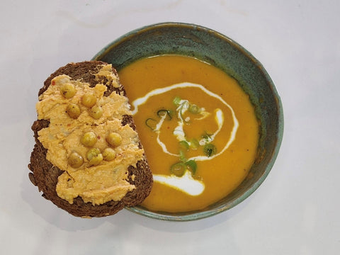 pittige oosterse wortel-tomatensoep met toast en homemade hummus